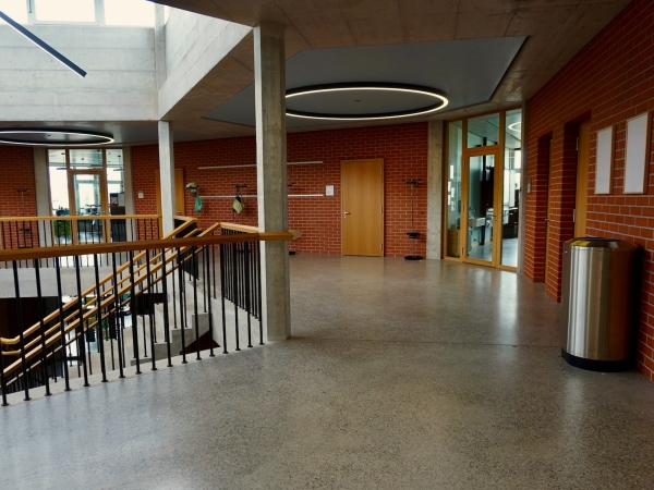 A modern-looking empty school interior with natural light and a staircase
