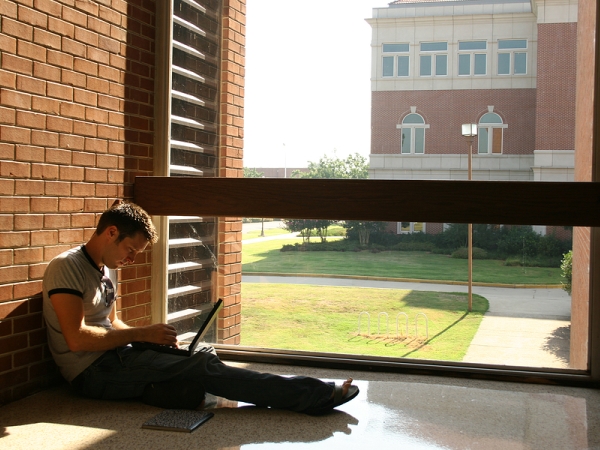 Seated student studying on a college campus
