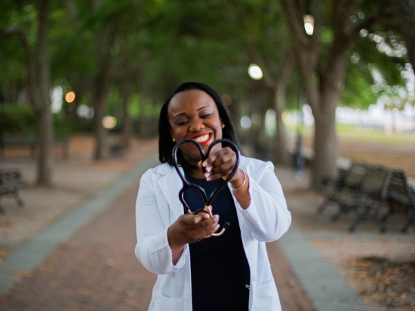 Doctor in park forms stethoscope into heart