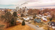 small town aerial shot with homes and factory in background