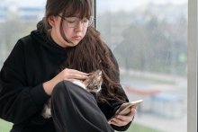 A girl with a cat sits at a window looking at the gray San Francisco sky and wondering what she'll do once her family is evicted